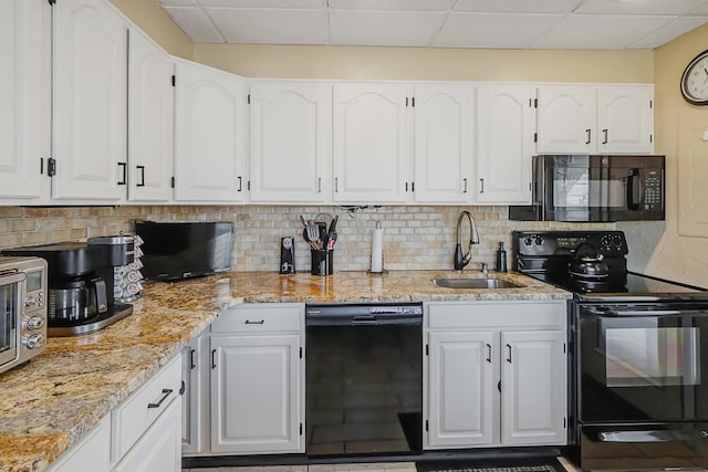 kitchen featuring a sink, backsplash, black appliances, and white cabinets