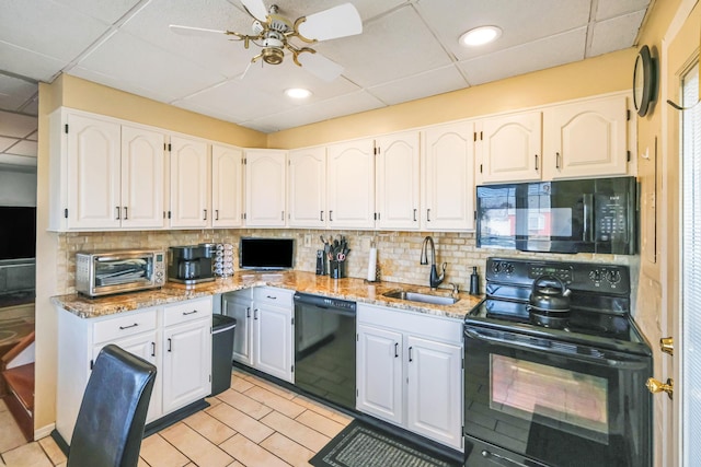 kitchen featuring a sink, decorative backsplash, black appliances, and white cabinetry