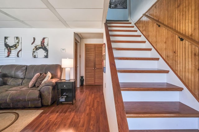 staircase featuring a drop ceiling and wood finished floors