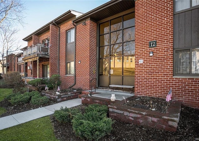 doorway to property featuring brick siding