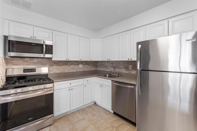 kitchen with a sink, stainless steel appliances, and white cabinets