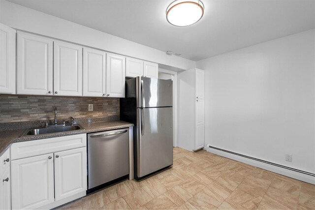 kitchen featuring a sink, tasteful backsplash, dark countertops, appliances with stainless steel finishes, and a baseboard radiator