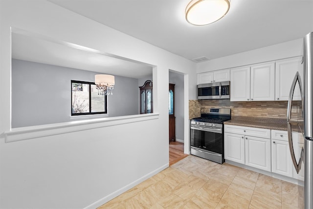 kitchen with visible vents, appliances with stainless steel finishes, white cabinets, and a chandelier