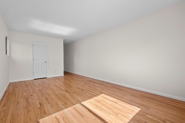 empty room with baseboards and light wood-style floors