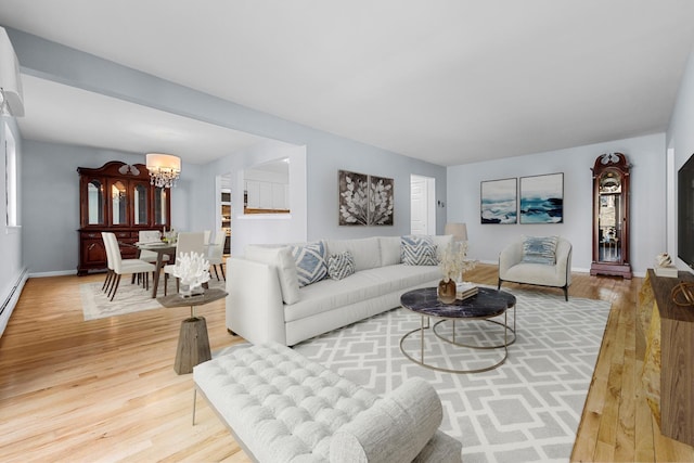 living room featuring baseboards, wood finished floors, and a chandelier