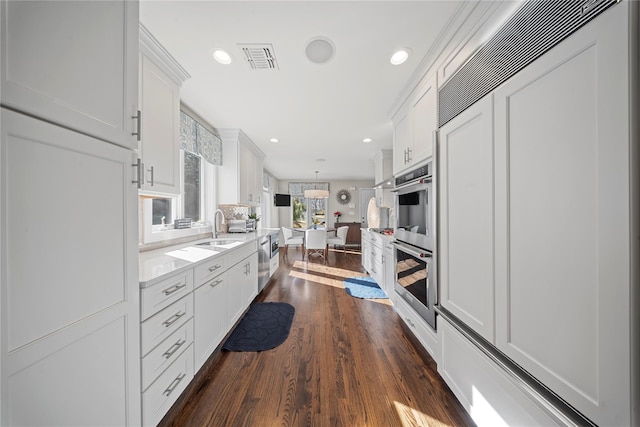 kitchen with visible vents, dark wood finished floors, light countertops, appliances with stainless steel finishes, and white cabinets