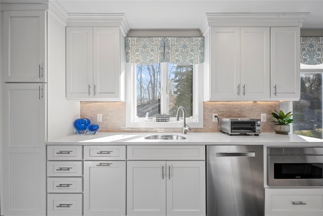 kitchen with dishwasher, light countertops, white cabinets, and a sink