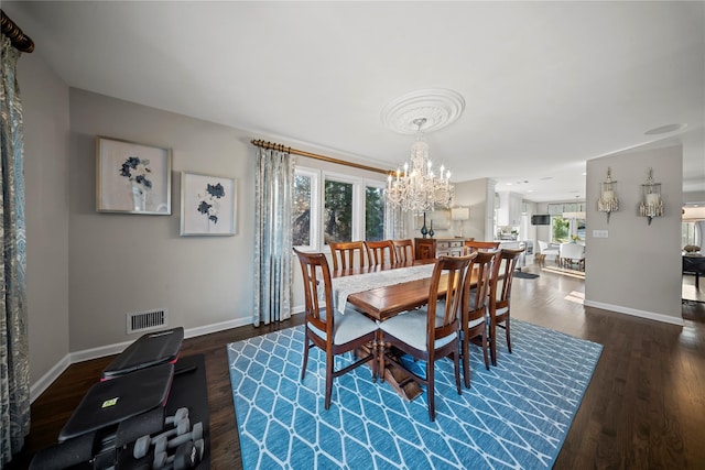 dining space with dark wood finished floors, plenty of natural light, an inviting chandelier, and visible vents