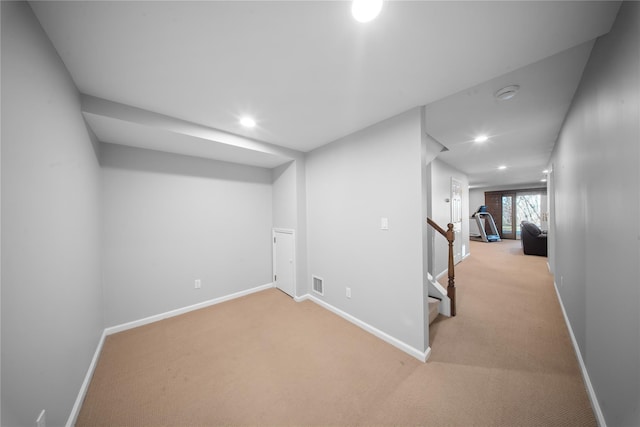 below grade area with recessed lighting, visible vents, baseboards, and light colored carpet