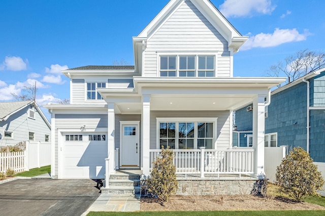 view of front of property featuring a porch, fence, a garage, and driveway