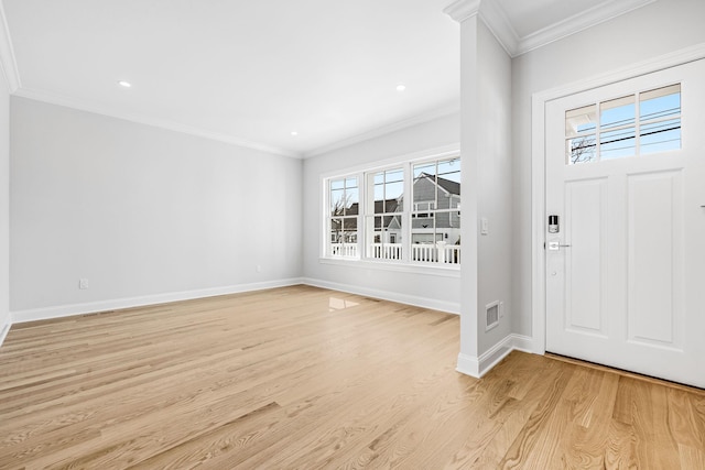 foyer entrance with visible vents, a healthy amount of sunlight, and ornamental molding