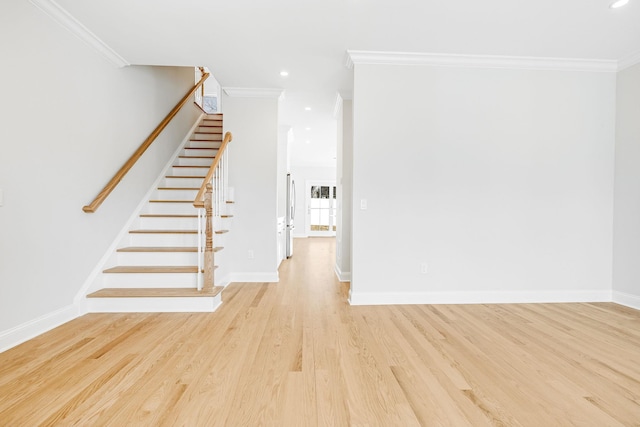 interior space featuring stairs, light wood-type flooring, baseboards, and ornamental molding