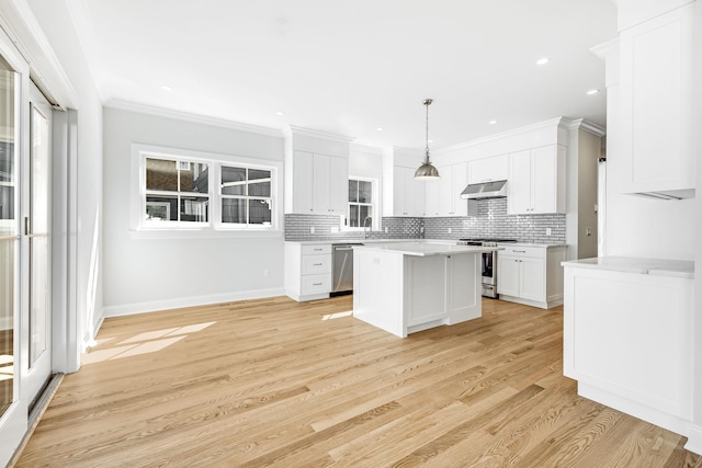 kitchen featuring backsplash, under cabinet range hood, light countertops, white cabinets, and stainless steel appliances