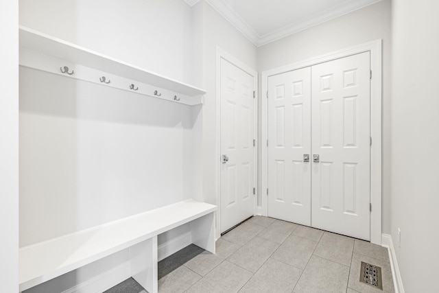 mudroom with light tile patterned floors, visible vents, baseboards, and crown molding