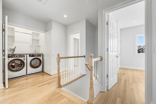 laundry room featuring light wood-type flooring, baseboards, separate washer and dryer, and laundry area