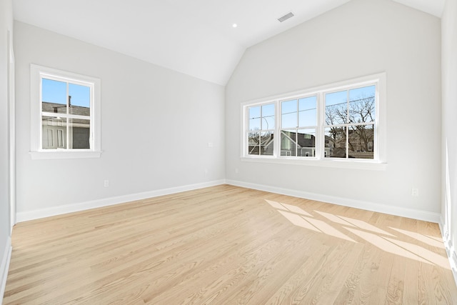 unfurnished room with baseboards, lofted ceiling, visible vents, and light wood-style flooring