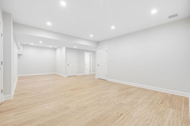 below grade area with recessed lighting, visible vents, baseboards, and light wood-style floors