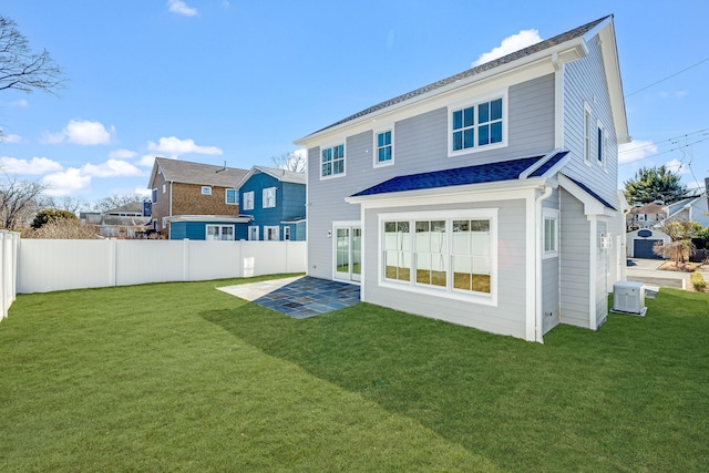 rear view of house featuring a patio area, a lawn, and fence