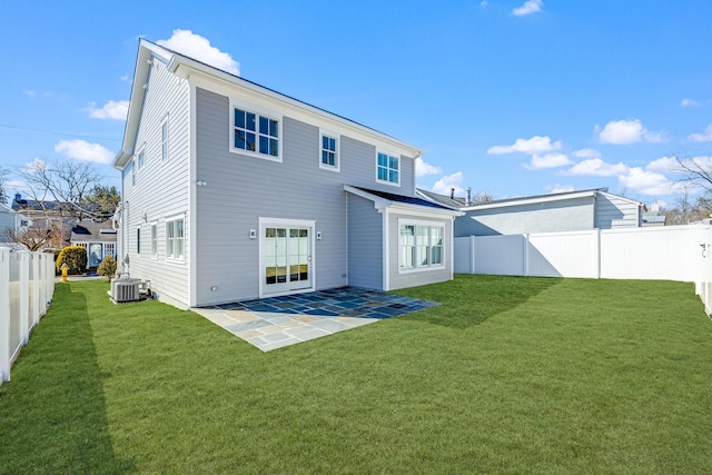 rear view of property featuring a yard, a patio, a fenced backyard, and central air condition unit