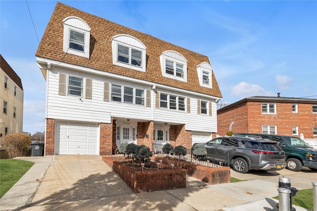 view of front of property with brick siding, roof with shingles, concrete driveway, and an attached garage