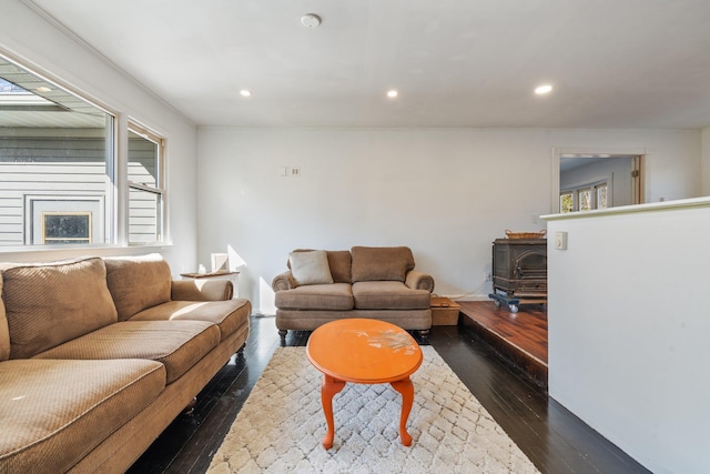 living area with recessed lighting, dark wood-style floors, and a wood stove