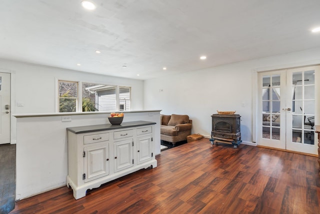 kitchen featuring a wood stove, french doors, dark wood-style flooring, and white cabinets