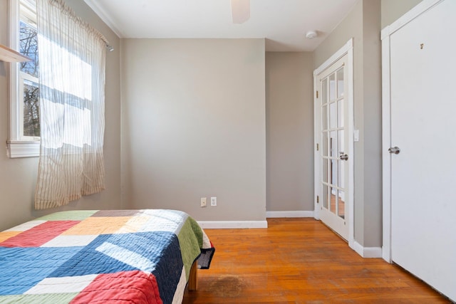 bedroom featuring ceiling fan, baseboards, and wood finished floors