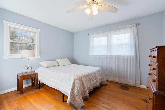 bedroom featuring baseboards, light wood-style floors, and ceiling fan