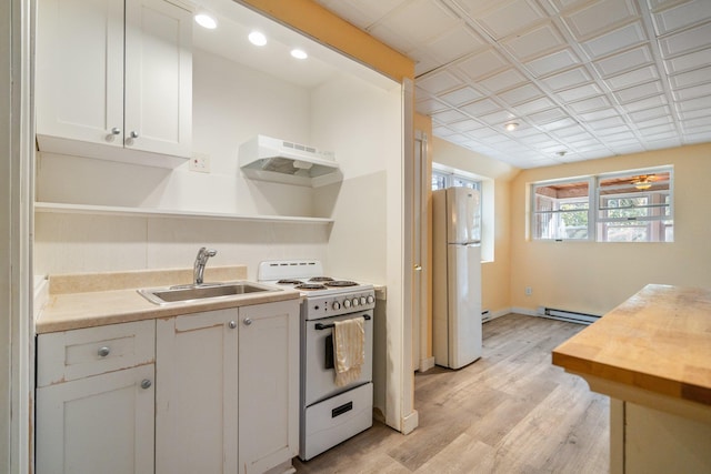 kitchen with under cabinet range hood, open shelves, white appliances, and a sink