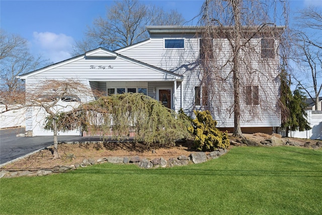 view of front facade featuring a garage, driveway, and a front yard