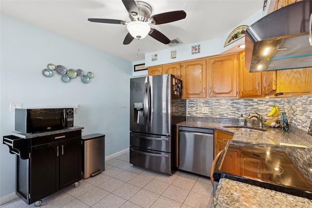 kitchen featuring visible vents, under cabinet range hood, a sink, backsplash, and stainless steel appliances