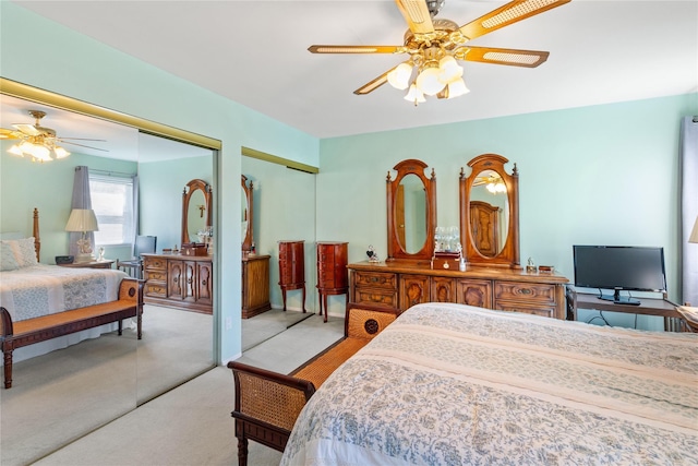 bedroom featuring a ceiling fan, two closets, and light carpet