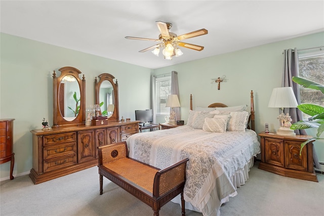 bedroom with light colored carpet, a ceiling fan, and a baseboard radiator