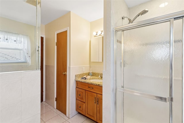 full bath featuring visible vents, vanity, a stall shower, tile patterned floors, and tile walls