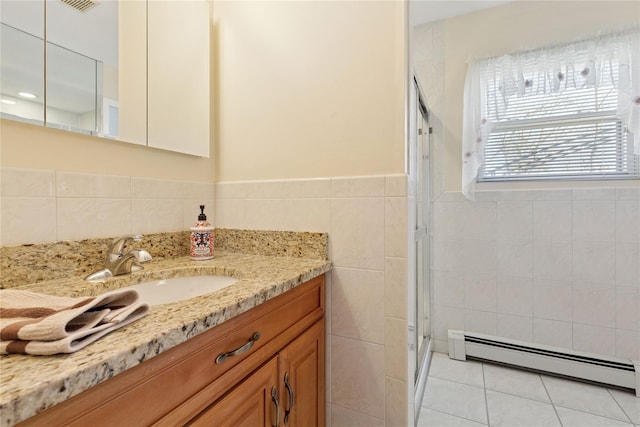 bathroom featuring a shower stall, vanity, tile patterned floors, tile walls, and a baseboard radiator