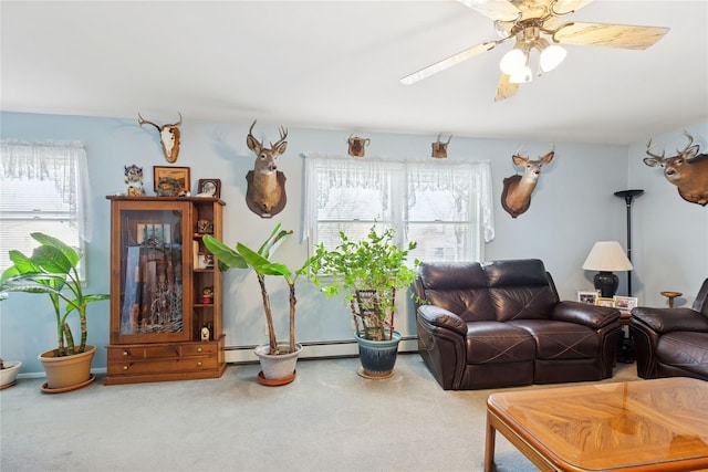 living area with a baseboard heating unit, a ceiling fan, and carpet floors