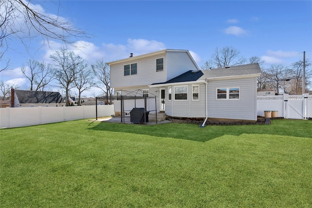 rear view of house featuring a patio, a lawn, a fenced backyard, and a gate