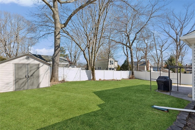 view of yard with an outdoor structure, a fenced backyard, a shed, and a patio