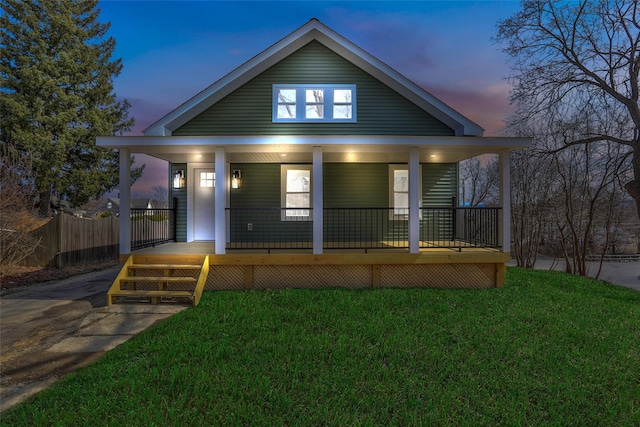 bungalow with a yard, a porch, and fence