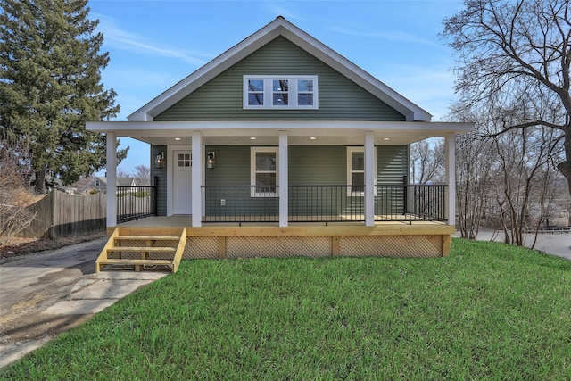 bungalow with a front yard, fence, and covered porch