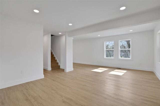 basement with stairway, recessed lighting, light wood-type flooring, and baseboards