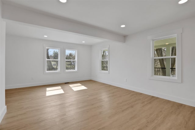 spare room featuring beam ceiling, recessed lighting, baseboards, and light wood finished floors