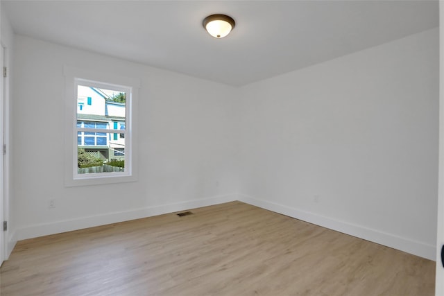 empty room featuring visible vents, baseboards, and light wood-style floors