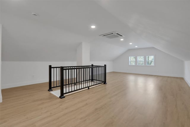 additional living space with visible vents, baseboards, lofted ceiling, and wood finished floors