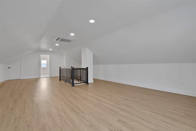 bonus room featuring baseboards, visible vents, light wood-style flooring, recessed lighting, and vaulted ceiling