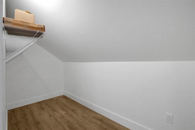 additional living space with baseboards, lofted ceiling, and wood finished floors