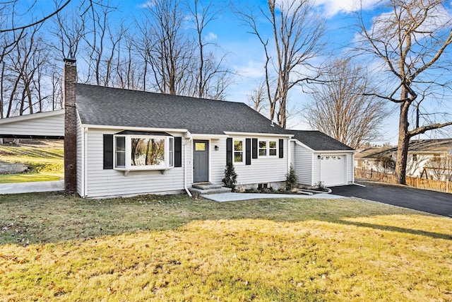 view of front of property with a front yard, roof with shingles, an attached garage, a chimney, and aphalt driveway