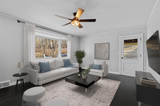 living area featuring wood finished floors, a healthy amount of sunlight, visible vents, and baseboards