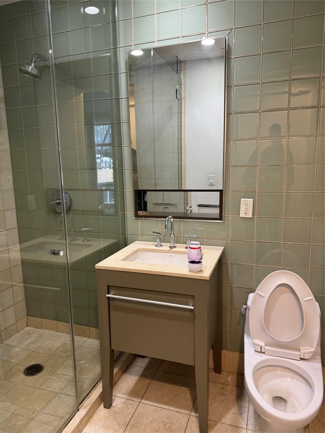 full bath featuring vanity, a stall shower, tile patterned flooring, tile walls, and toilet