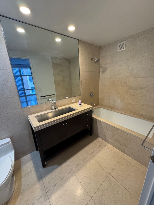 full bathroom featuring tile patterned flooring, toilet, tile walls, and tiled shower / bath combo